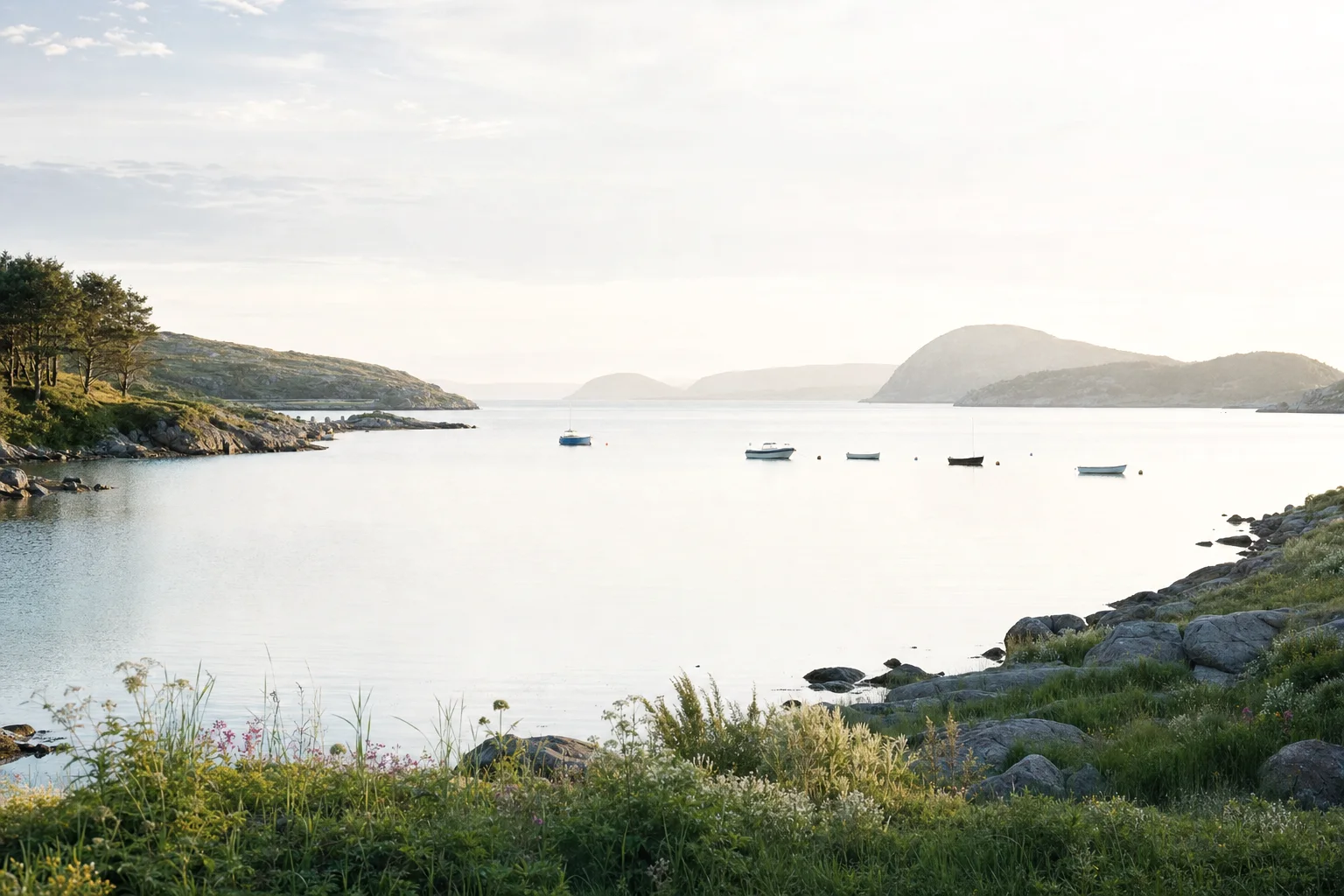 Small boats on a quiet bay, with wooded hills along the shore